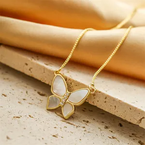 Elegante collana a farfalla dorata con intarsio in madreperla bianca su sfondo di pietra