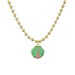 Collar de cuentas doradas con colgante de concha de esmalte y pequeñas piedras de colores