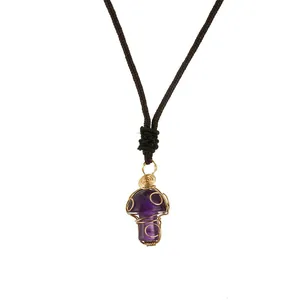 Handmade wire-wrapped purple crystal mushroom pendant on dark brown woven cord