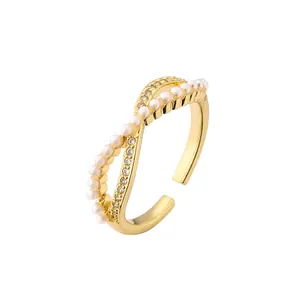 Bague dorée croisée avec des perles blanches et des oxydes de zirconium brillants