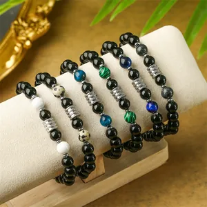 Cinco pulseras de cuentas con ojo de tigre y obsidiana en cojín de exhibición
