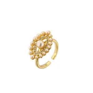 Bague ouverte dorée ornée d'une grande perle entourée de petits strass et perles