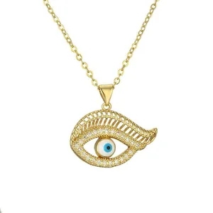 Gold evil eye necklace with colorful crystals and blue enamel on white background