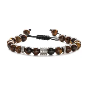 Adjustable tiger eye beaded bracelet with silver metal charms on a white background