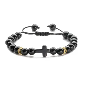 Braided bracelet featuring black lava beads and a black cross with gold diamond-set accents