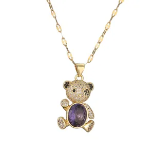 Golden necklace with micro-paved bear pendant featuring a large oval purple crystal