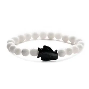 Minimalist beaded bracelet featuring white round stones and a black sandstone penguin bead