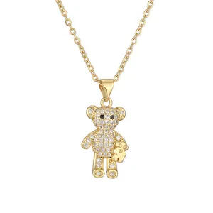 Golden teddy bear necklace with pave zirconia and holding a miniature gold bear charm