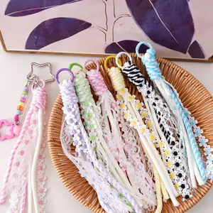 Detail of handmade lace and floral tassel charms in macaron colors for keychains