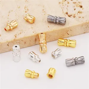 Peanut screw clasps for jewelry making in gold, silver, and grey on a stone tray