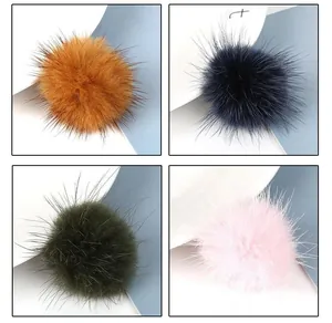 Detail of soft 3.5cm faux fur pom-poms in brown, navy, dark green, and pink colors