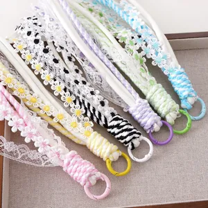Detailed close-up of colorful floral lace tassels with metal alloy keyrings on a tray