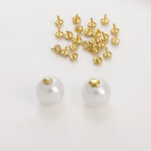 Macro shot of large round white pearls with golden floral pattern caps and jewelry findings