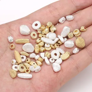 Frosted gold and silver copper beads set for DIY jewelry making held in palm