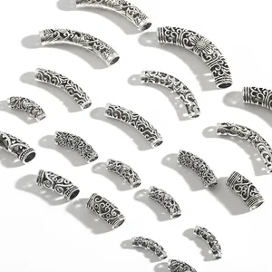 Macro view of antique silver alloy curved tube beads with floral engravings for DIY jewelry