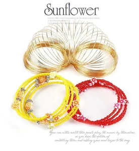 Detail of multi-layer beaded bracelets with floral charms in vibrant red and yellow