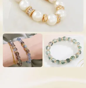 Dettaglio di distanziatori placcati oro 18K con zirconi su bracciali di perle e pietre