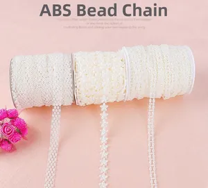 Detail of three rolls of white ABS bead chain for DIY crafts and sewing decoration