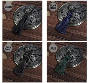 Detail of silk tassels in black, dark blue, brown, and green with bronze metal caps