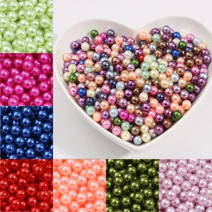 Assortiment de perles d'imitation ABS colorées dans un bol pour la création de bijoux DIY