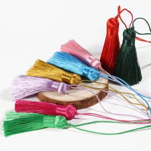 Handmade 5.5mm silk tassels in eight vibrant colors on a natural wooden display