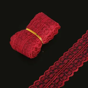 Deep red embroidered lace ribbon roll with intricate floral patterns and scalloped edges