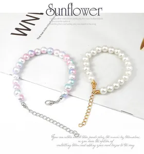 Detail of multi-color and white pearl bracelets with adjustable metal extender chains