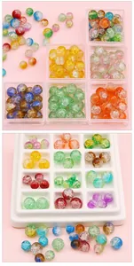 Makroaufnahme bunter Glasperlen mit Crackle-Effekt für DIY-Schmuck in einer Aufbewahrungsbox