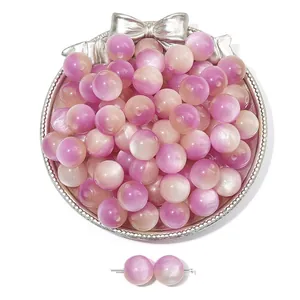 Macro shot of pink and purple gradient resin cat-eye beads in a silver vintage tray