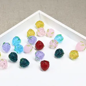 Perline di vetro a forma di fragola per gioielli fai-da-te in un vassoio bianco