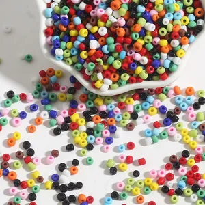 Colorful 2-4mm glass seed beads scattered from a white ceramic bowl for DIY jewelry