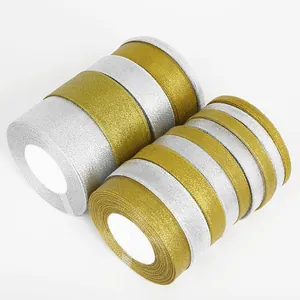 Macro detail of gold and silver glitter ribbon rolls for gift wrapping and DIY crafts