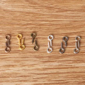 Close-up of metal screw eye pins in six colors on wooden surface for jewelry making