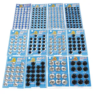 Assorted silver and black metal snap buttons set on blue cards for sewing and DIY crafts