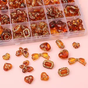 Lot de perles en acrylique ambre avec bordure dorée, formes cœur et papillon en boîte