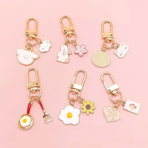 Set of six cute cartoon metal keychains with pink hearts, cats and clouds on pink background