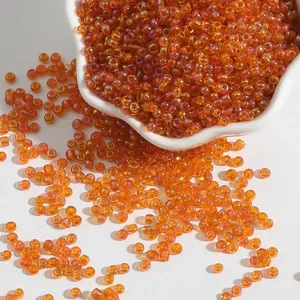 Perles de rocaille en verre ambré irisées pour bijoux DIY dans un bol blanc