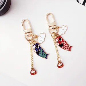 Detail of Japanese koi carp flag keychains with colorful enamel finish and Daruma charms