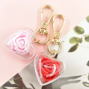 Close-up of heart-shaped keychains with pink and red roses in transparent shells