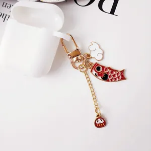 Japanese style koi fish and daruma lucky keychain with golden lobster clasp on white surface