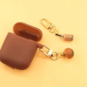 Close-up of brown silicone earphone case with golden bubble tea pendants for AirPods