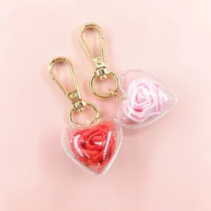 Macro detail of heart-shaped preserved rose keychain with red and pink floral inserts