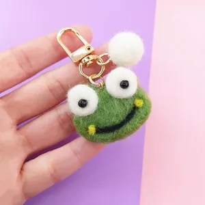 Gros plan d'un porte-clés grenouille en feutre fait main avec fermoir doré en métal