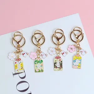 Detailed view of four colorful Japanese Omamori keychains with cherry blossom charms