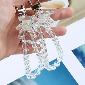 Détail de breloques ours en cristal aurore avec dragonne perlée et fermoir métallique