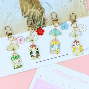 Vue détaillée de breloques japonaises avec fleurs de cerisier et étiquettes omamori dorées