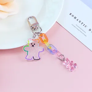 Cute acrylic bear keychain with jelly-colored chain and glitter details on a display tray