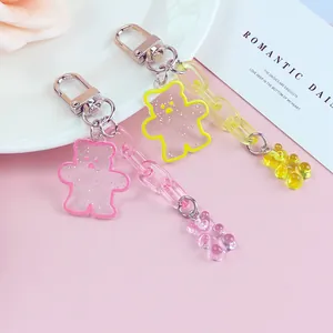 Cute acrylic glitter bear keychains with plastic chains and metal hooks on pink background