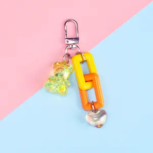 Detail of colorful resin bear keychain with acrylic chain and iridescent heart pendant