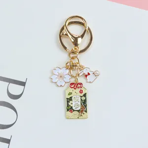 Macro view of Japanese cherry blossom bunny omamori keychain in gold plated metal finish